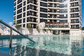 A modern hotel with a pool, multiple balconies, and a clear view of the surrounding area. - The Tower (Asunción)