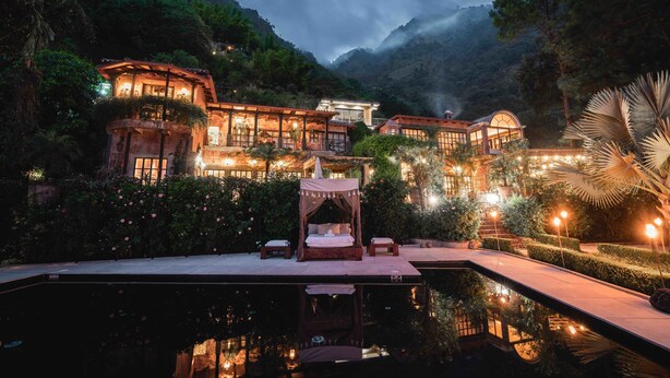A luxurious resort with a large swimming pool, a well-lit outdoor area, and a canopy bed. - Casa Prana Hotel In Atitlan (Santa Cruz La Laguna)