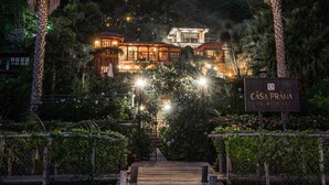 A wooden pathway leading to a building with a sign reading "CASA PRANA BE WITH US." - Casa Prana Hotel In Atitlan (Santa Cruz La Laguna)