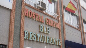 A building with a sign for a bar and restaurant named "Postal Serpón". - Hostal Serpol (Palencia)