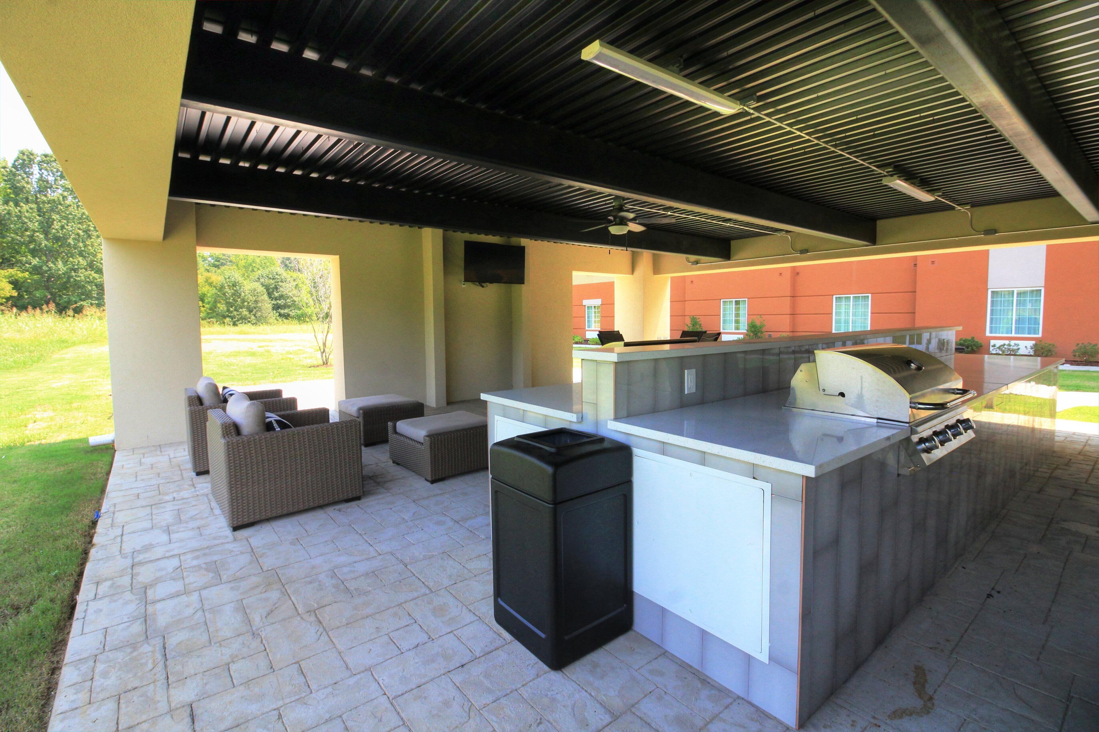 Een buitenkeuken met een barbecue, zitplaatsen en uitzicht op het omliggende landschap.