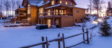 Un gran albergue de madera con varios balcones y un paisaje cubierto de nieve.