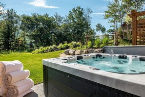 Ein Whirlpool mit einer Rasenfläche und Bäumen im Hintergrund.