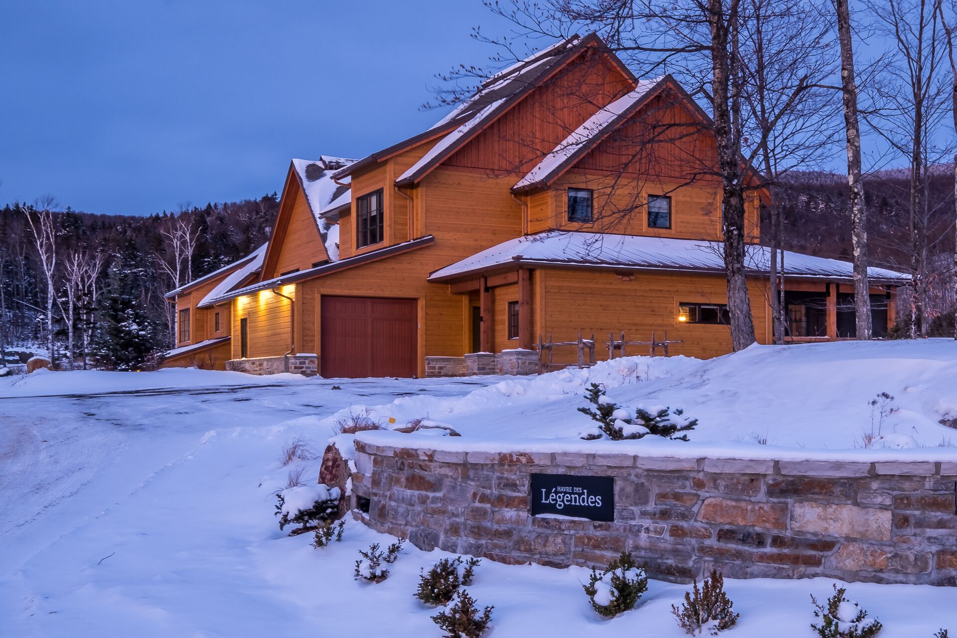 A large wooden lodge with a stone wall entrance and a sign reading "HAVRE DES LEGENDES".