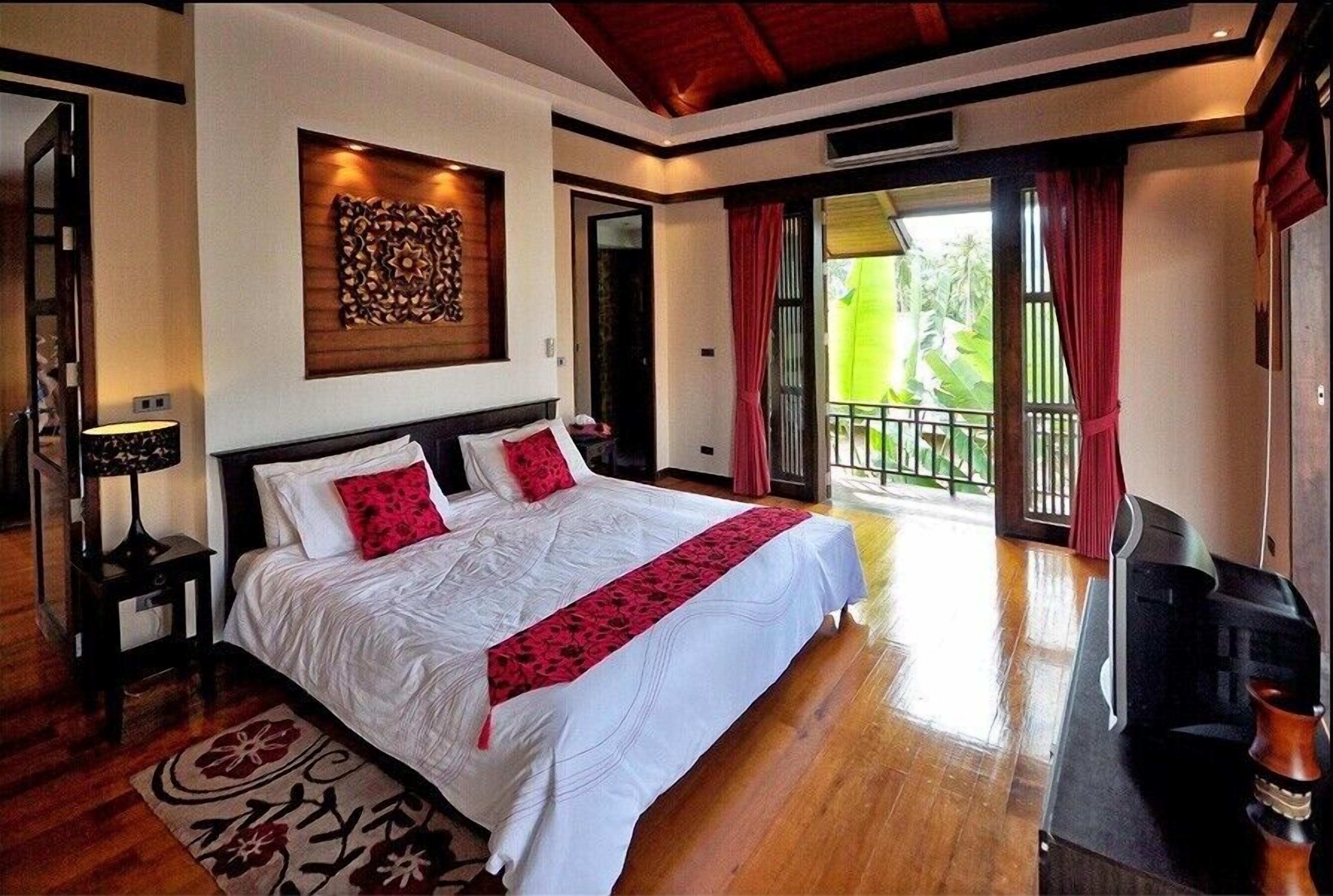 A spacious bedroom with a large bed, a wooden headboard, and a decorative wall piece.