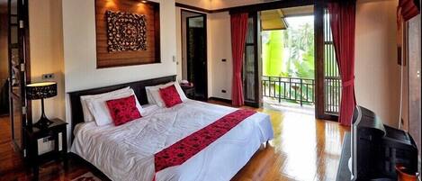 A spacious bedroom with a large bed, a wooden headboard, and a decorative wall piece.