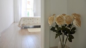 A bedroom with a bed, a bedside table, and a vase with roses. - Luxury Apartment In Centre Of Split (Split)