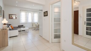 Una sala de estar moderna con un sofá, una mesa de centro y un comedor al fondo.