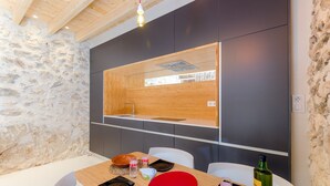 A modern kitchen with a stone wall, wooden ceiling, and a built-in sink. - CASA VELLA (VALL PETIT) - Chalet with terrace in Mancor De La Vall. Free WiFi (Mancor de la Vall)