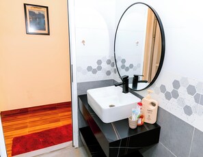 A bathroom with a white sink, black countertop, and a mirror. - Song Toan Hotel (Bo Trach)