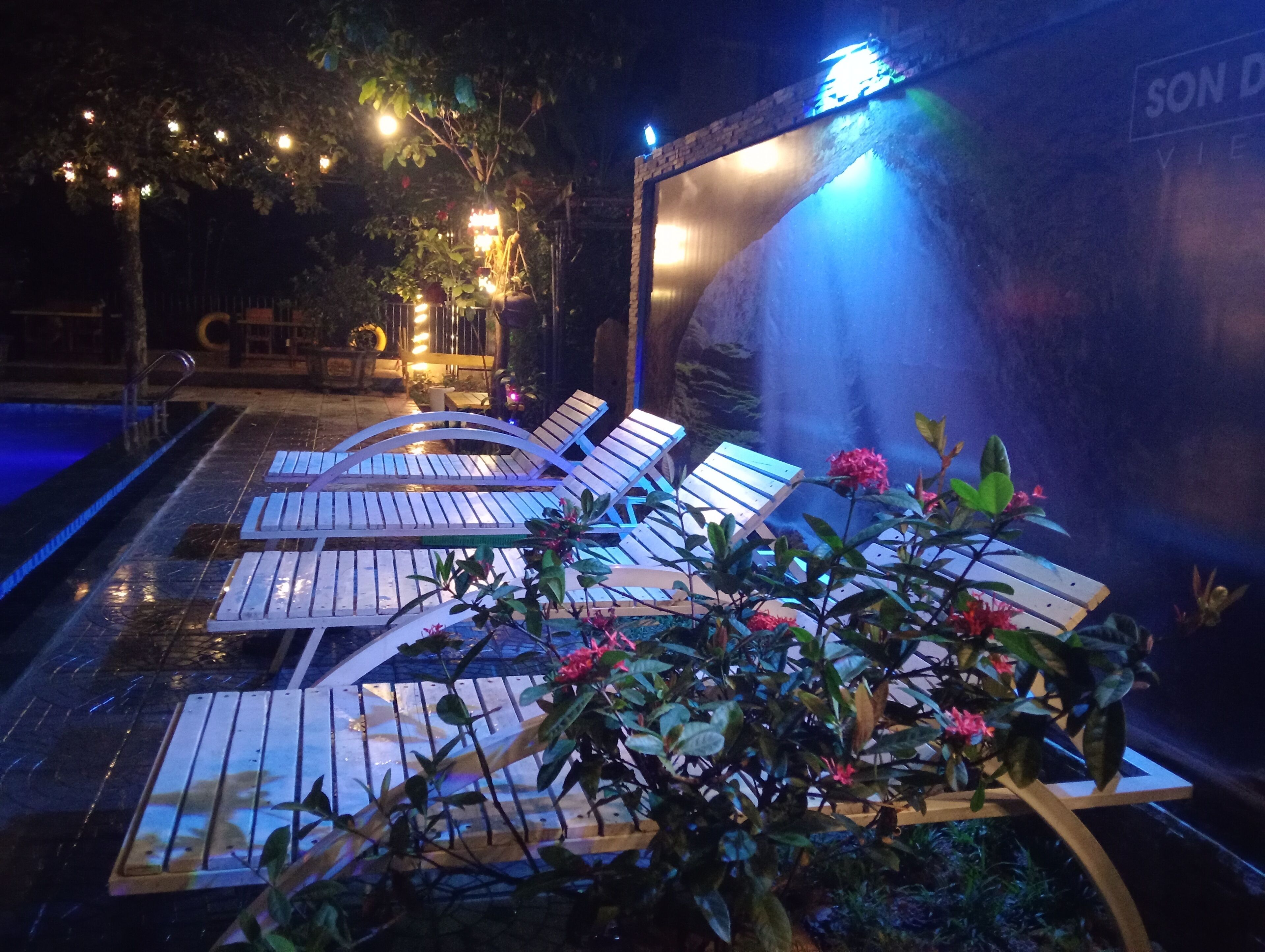 A poolside area with lounge chairs and a water feature.