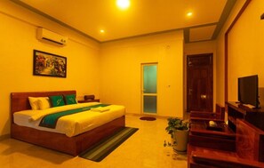 A hotel room with a bed, a television, a desk, and a potted plant. - Song Toan Hotel (Bo Trach)