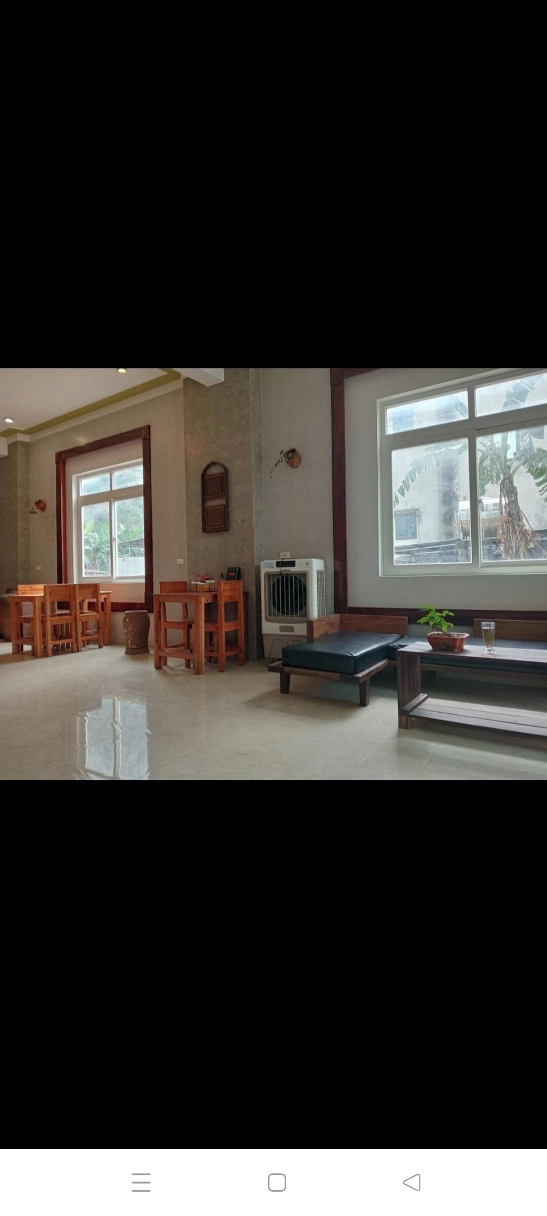 Ein Zimmer mit Holzmöbeln, einem großen Fenster und einer Heizung.