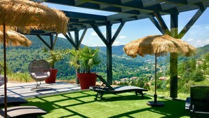Un espace extérieur abrité offrant une vue sur un paysage montagneux.