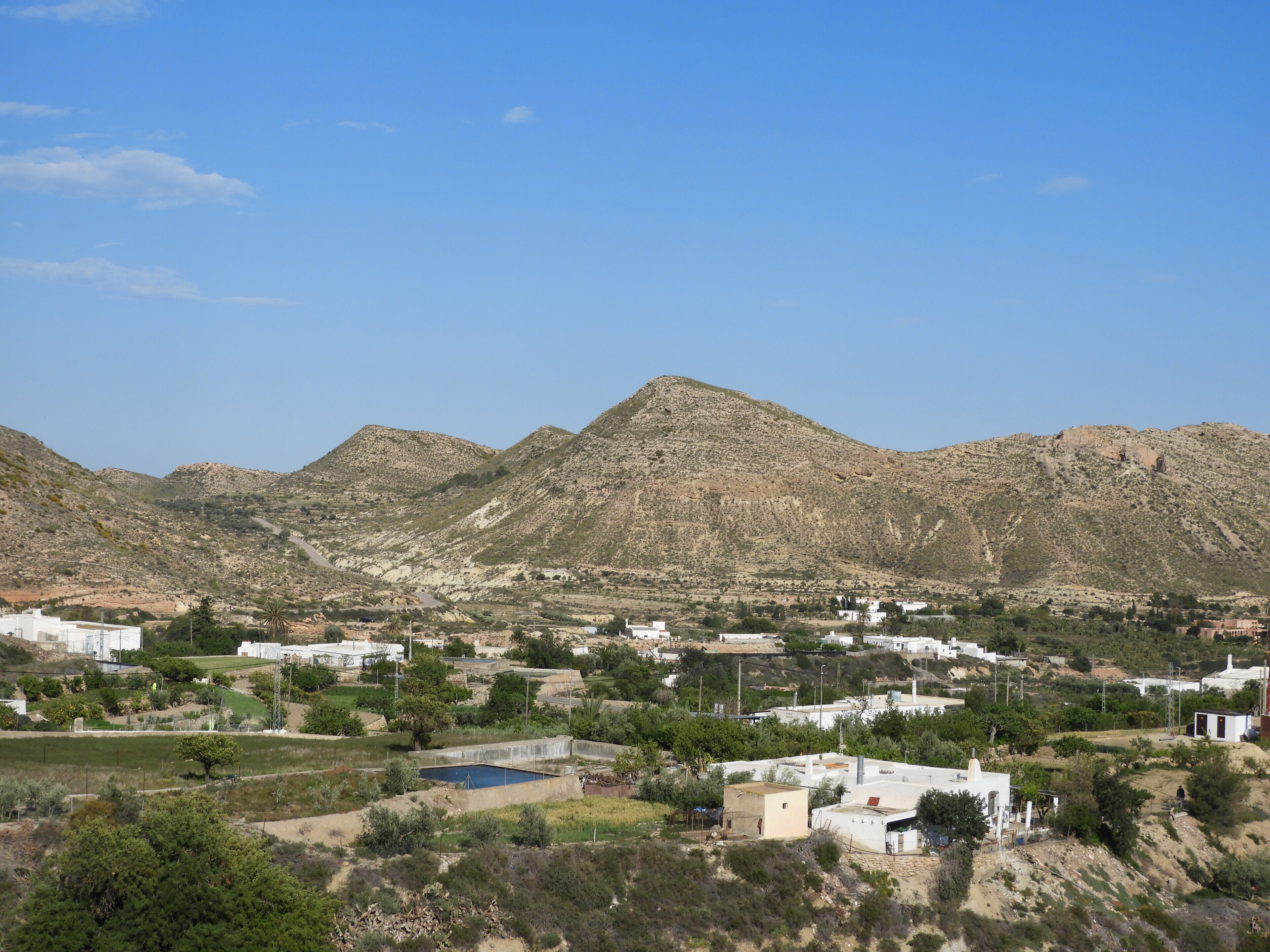 A mountainous landscape with a small settlement.