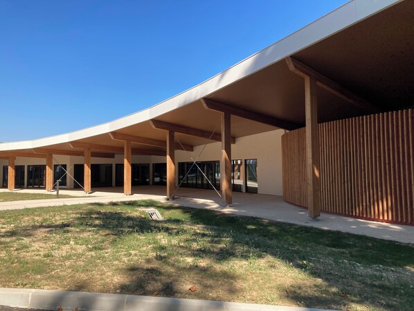 A modern building with a curved roof and large columns.