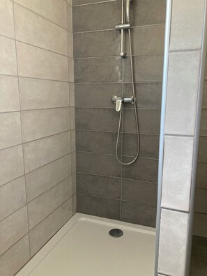 Een douche, een haardroger, handdoeken, toiletpapier