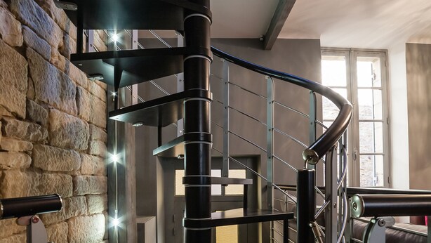 A spiral staircase with metal railings and a stone wall, leading to an upper level. - LE CLOS DE L'ABBAYE 4 * in the heart of the Cité Médiale de Sarlat + Free parking (Sarlat-la-Canéda)
