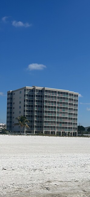 A multi-story hotel with a modern architectural design, featuring a grid of windows and balconies.