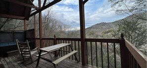 Enjoy a serene mountain view from this deck with a picnic table and two chairs.