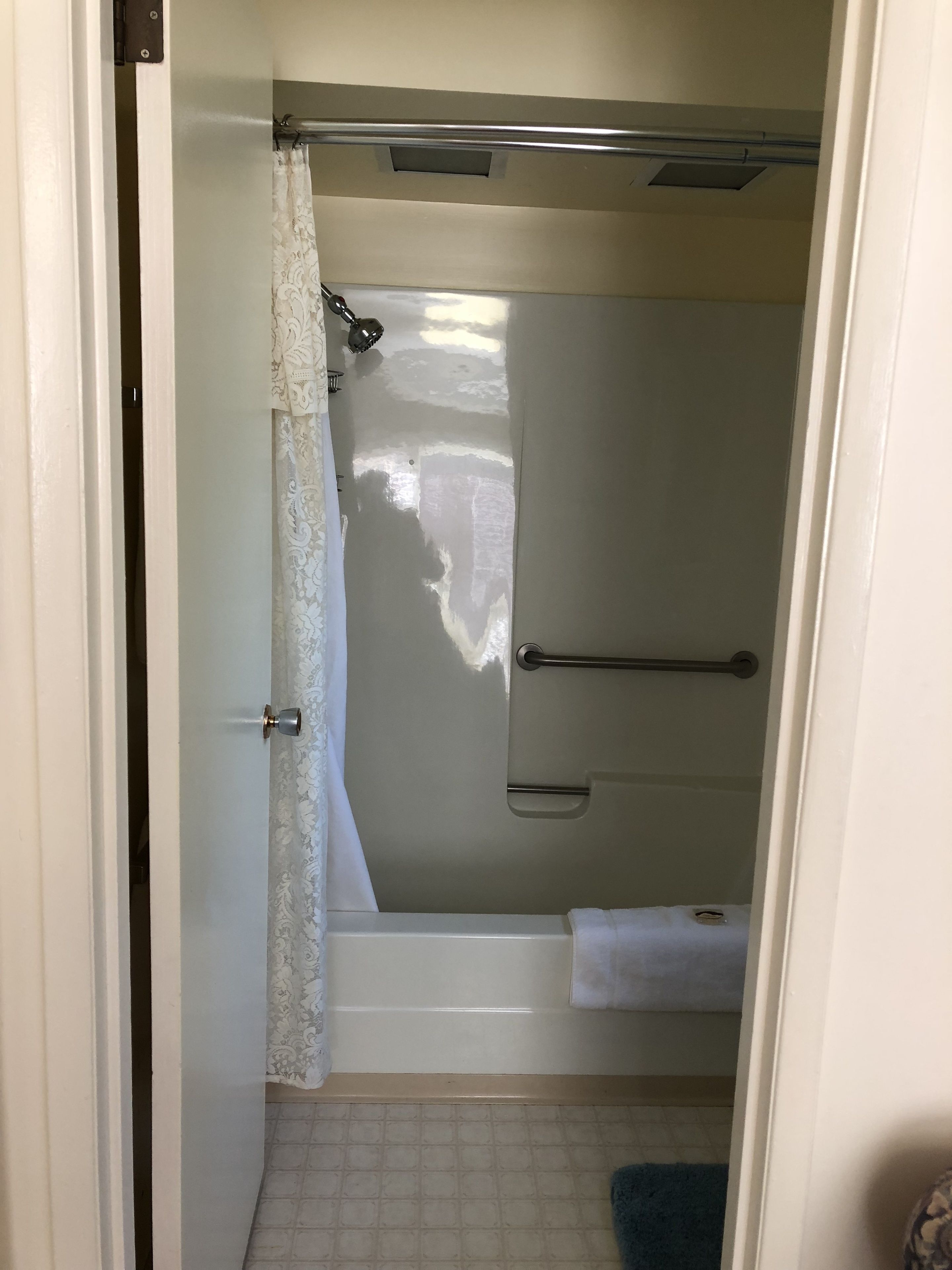 Une salle de bain avec une douche, un porte-serviettes et des toilettes.
