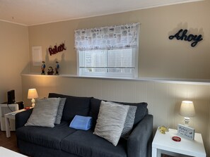 Relax in this inviting living room with a sofa, side table, and lamp.