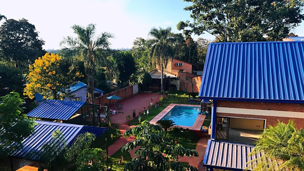 A residential area with multiple houses, a swimming pool, and lush greenery. - Hotel Amayal (Puerto Iguazú)