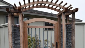 Une porte en bois, adossée à un mur de pierres, qui donne sur une allée.