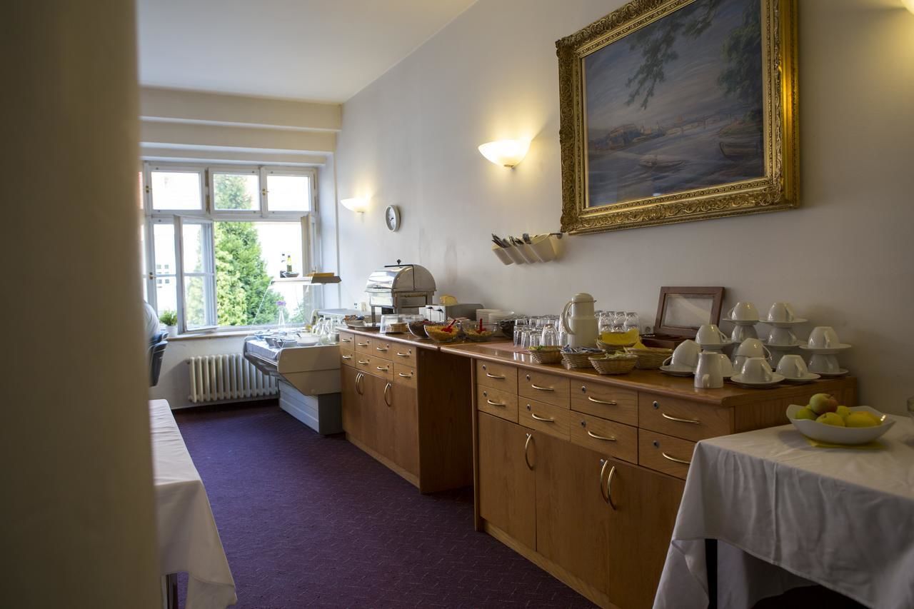 A kitchen with wooden cabinets, a dining table with a white tablecloth, and a painting on the wall.