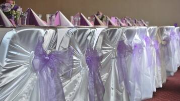 A table with a white tablecloth and purple sashes.