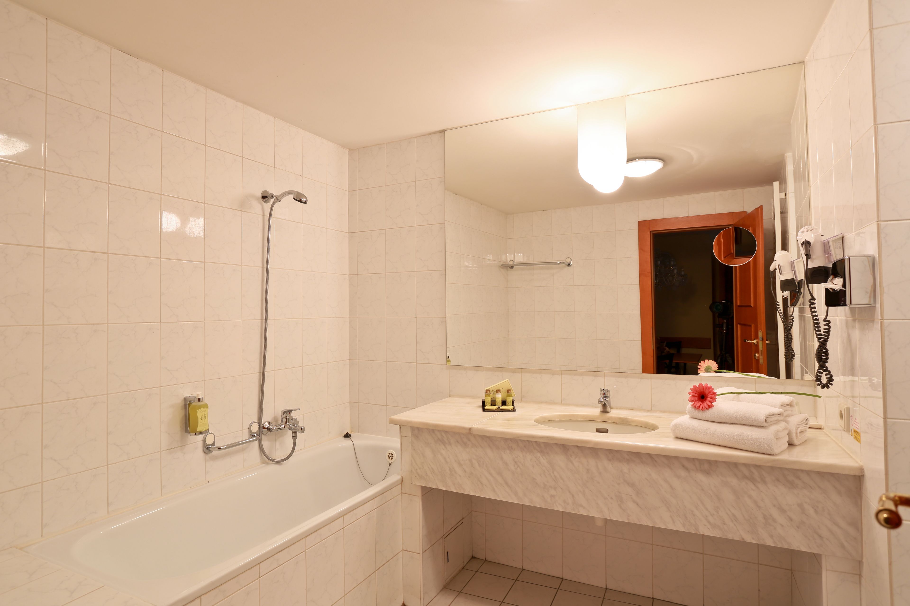 Un baño con bañera, lavabo y espejo.