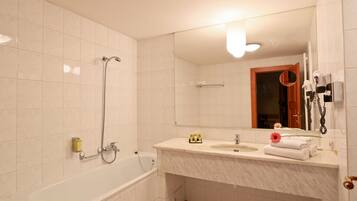 Un baño con bañera, lavabo y espejo.