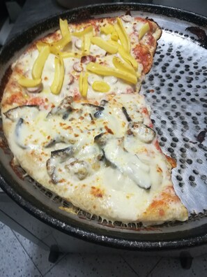Savor a freshly baked pizza with a variety of toppings, including mushrooms and bell peppers.