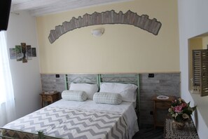 Cozy retreat with a chevron-patterned bedspread, green headboard, and a unique curved brick arch above the bed.