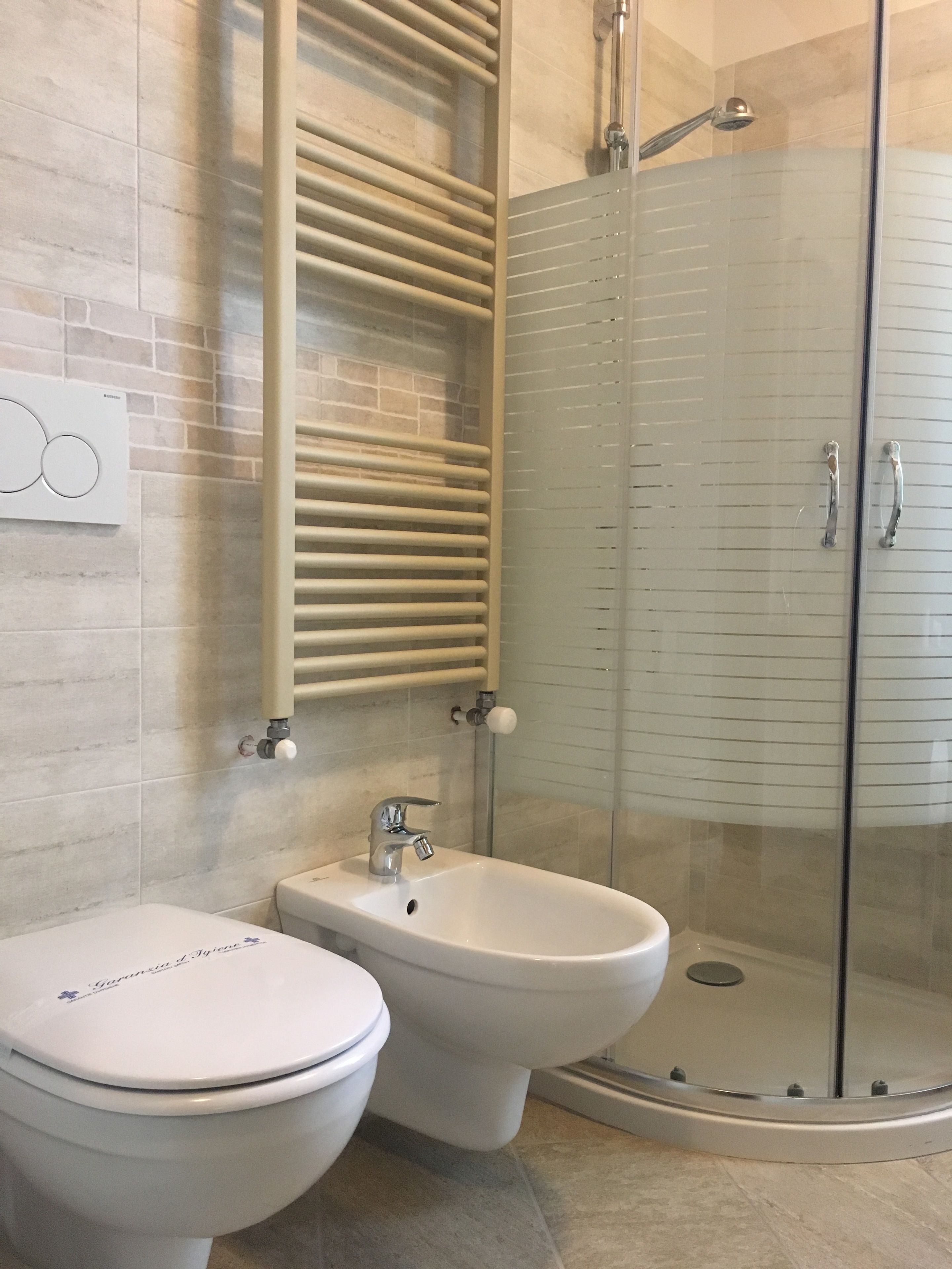 Ein Badezimmer mit Toilette, Bidet und einer Duschkabine.