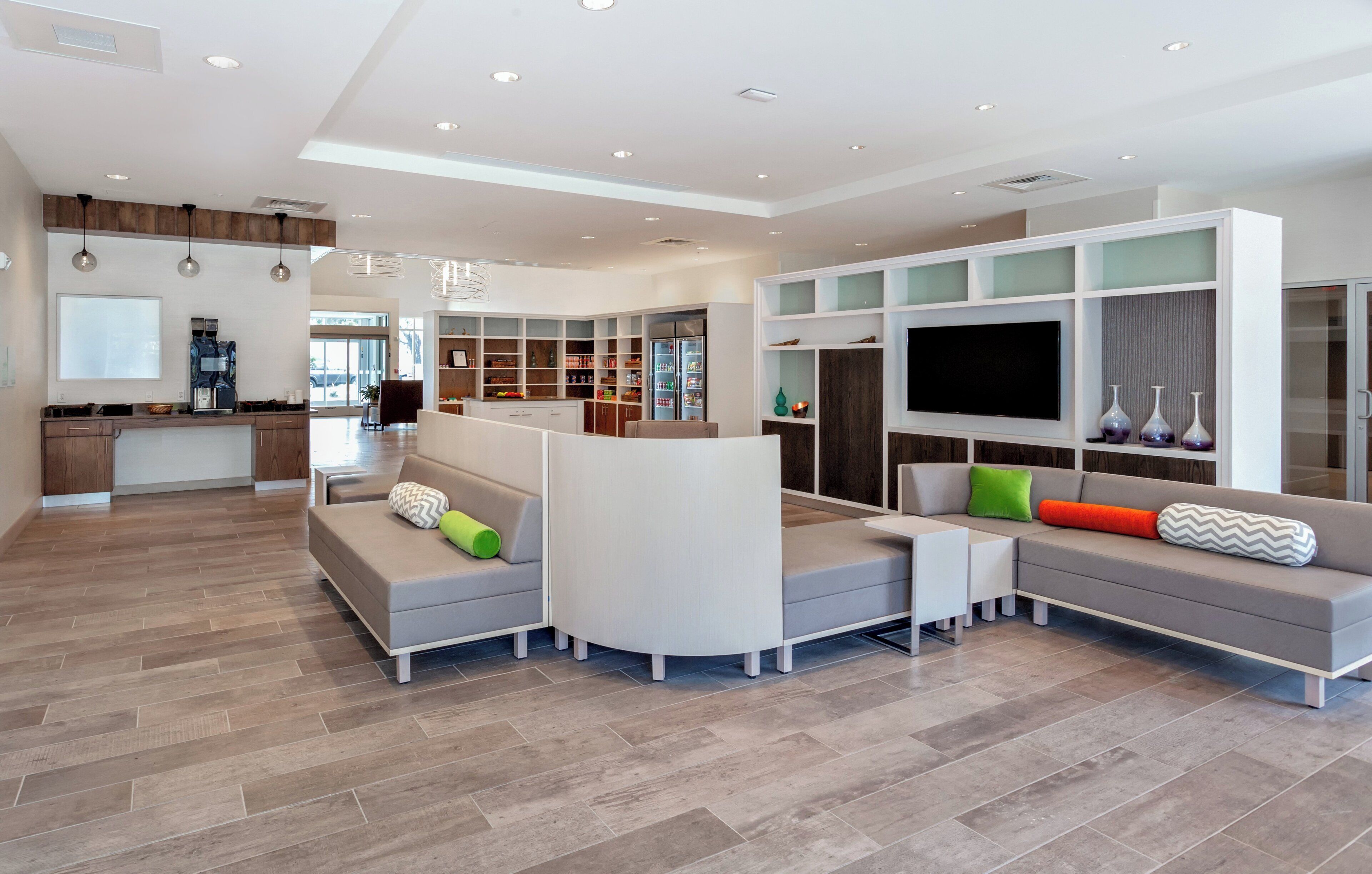 A modern living room with a sectional sofa, a flat-screen TV, and built-in shelving.