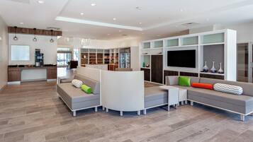 A modern living room with a sectional sofa, a flat-screen TV, and built-in shelving.