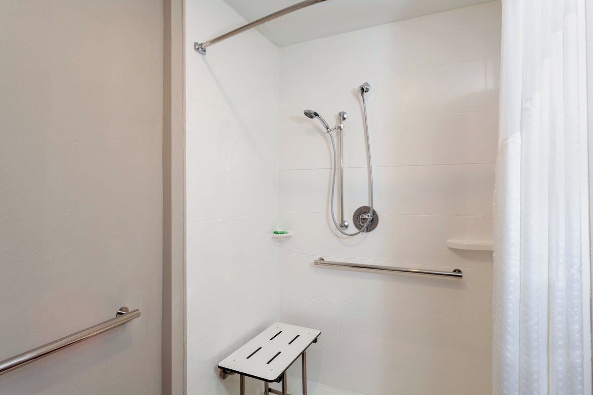 Eine Dusche mit Duschbrause, eine Duschbrause mit Schlauch und ein Handtuchhalter.