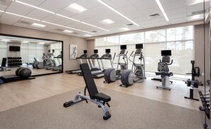 Ein Fitnessraum mit Laufbändern, Crosstrainern und Kurzhanteln.