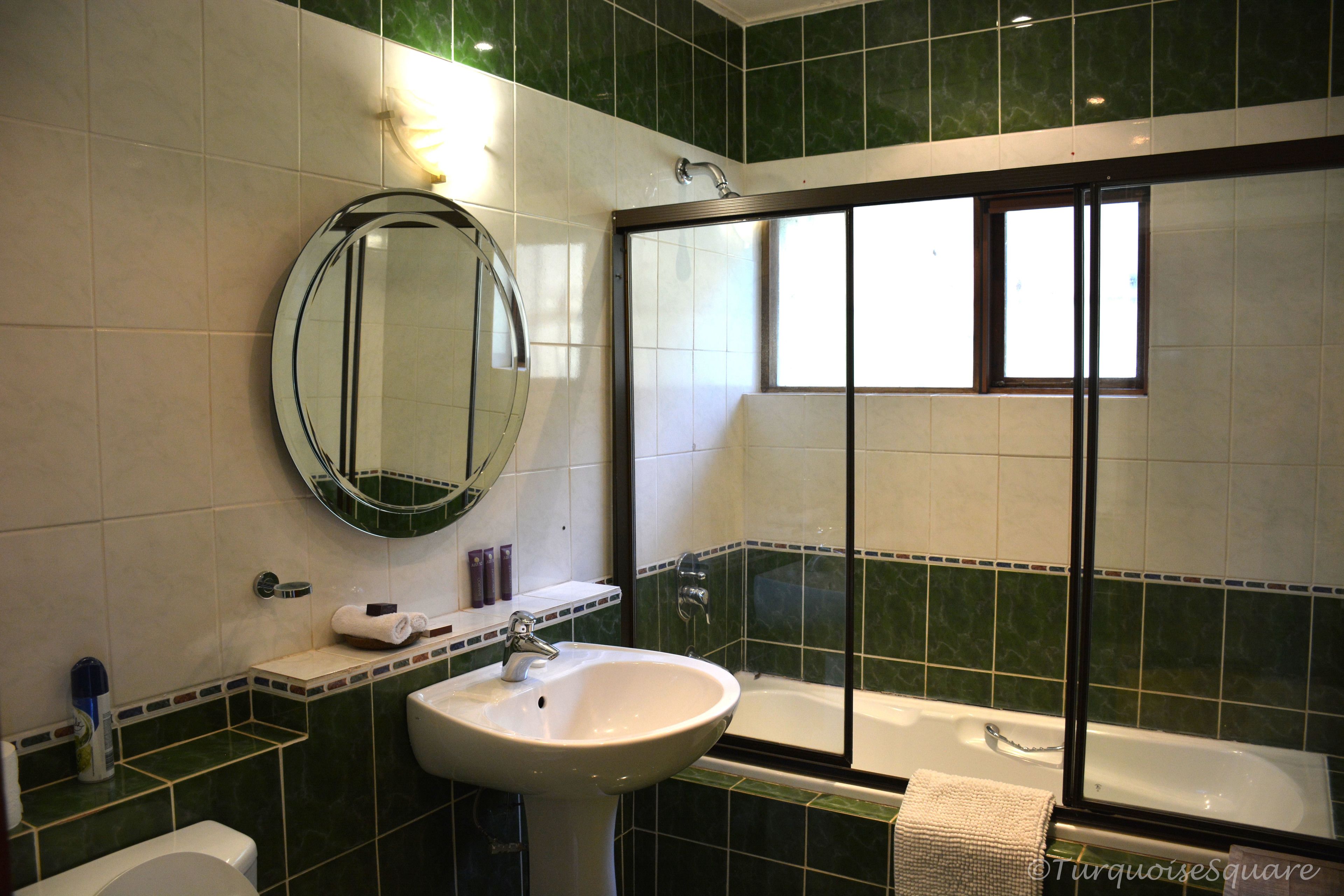 Un baño con lavamanos, espejo y bañera.