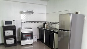 Een compacte keuken met een Bosch oven, een magnetron, een koelkast en een vaatwasser.