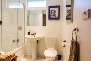 A bathroom with a glass-enclosed shower, a pedestal sink, a toilet, and a towel rack. - 3 & 4 Bedroom Houses in Seaview Crescent (Picton)