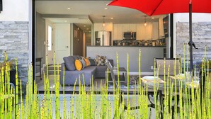 Un salon moderne avec un canapé, une table basse et un parapluie rouge.