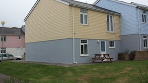 A two-story residential building with a picnic table in the front yard. - FANTASTIC LODGE - FREE FACILITIES And WiFi  (Newquay)