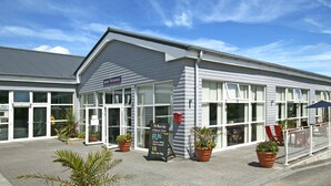 A building with a sign reading "The Manor House" and a signboard listing amenities like a restaurant, bar, and spa. - FANTASTIC LODGE - FREE FACILITIES And WiFi  (Newquay)