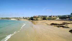 A beach with clear waters, a sandy shore, and buildings in the background. - FANTASTIC LODGE - FREE FACILITIES And WiFi  (Newquay)