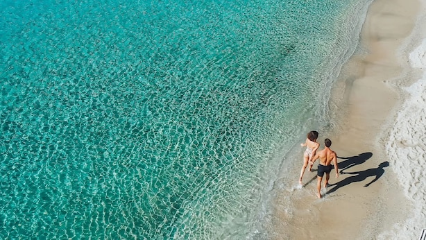 An aerial view of a beach with clear turquoise water and a sandy shore. - SEA & SUN A Quality Brand Certified Villa 150 meters from Agia Anna Beach (MYKONOS)