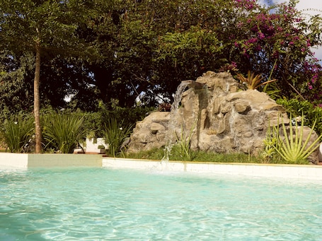 Una piscina al aire libre, sillones reclinables de piscina