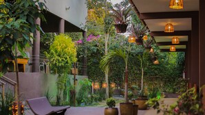 Un jardín al aire libre con un sendero, bancos y plantas en macetas.