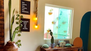Una habitación acogedora con una mesa de madera, un cactus en maceta y dos carteles motivacionales en la pared.